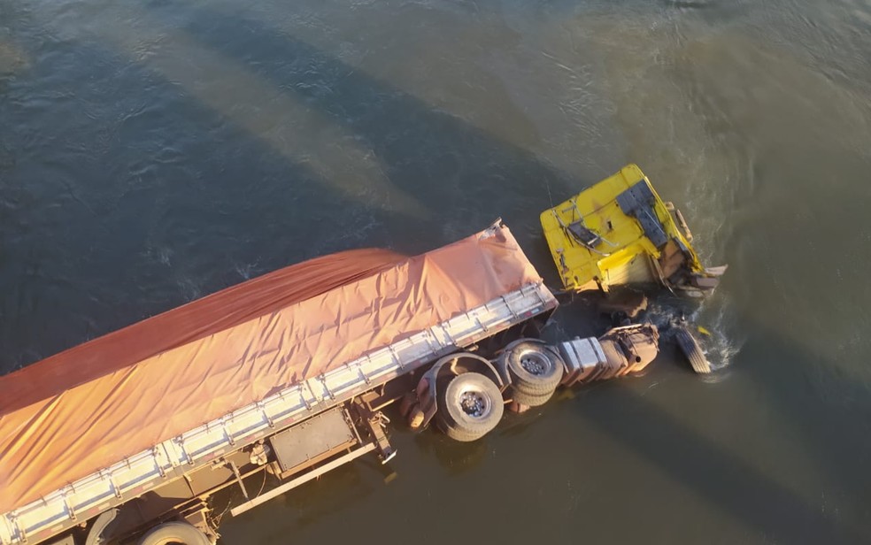 Motorista joga caminhão de ponte ao tentar evitar acidente, cai em rio e é resgatado por pescadores